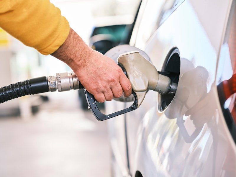 Hand using a fuel nozzle at a commercial fuelling station